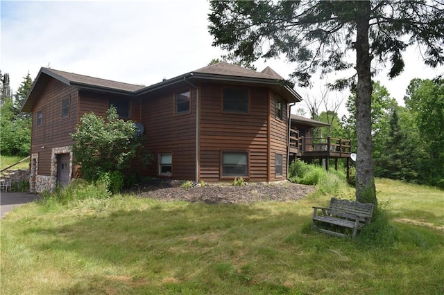 view of property exterior featuring a wooden deck, a yard, and a garage