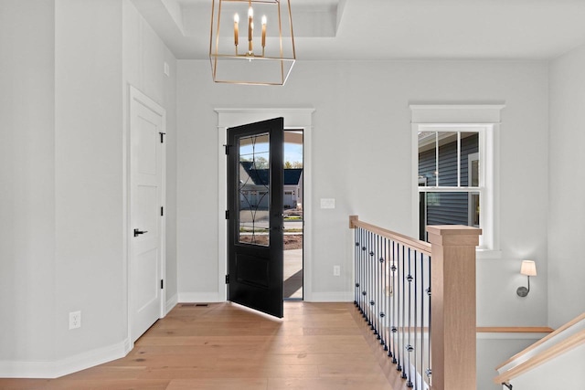 foyer with light hardwood / wood-style flooring and a chandelier