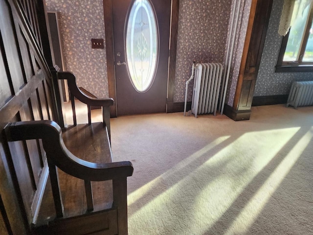 carpeted foyer entrance with radiator heating unit