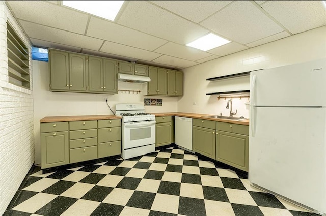 kitchen with brick wall, a drop ceiling, sink, and white appliances