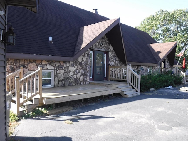 rear view of property featuring a wooden deck