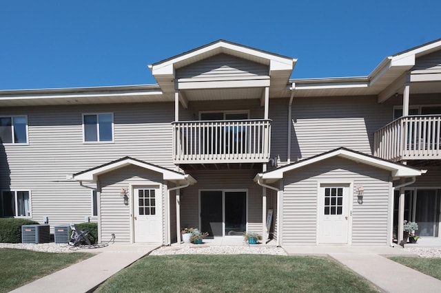 multi unit property featuring a front lawn and a balcony