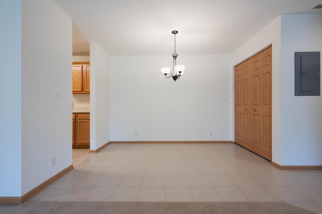 empty room featuring electric panel, a notable chandelier, and light tile patterned floors