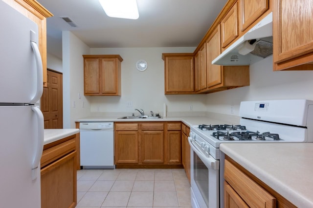 kitchen featuring white appliances, sink, and light tile patterned floors