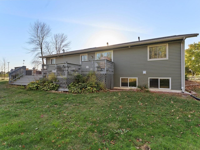 rear view of house featuring a deck and a lawn