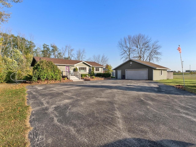 single story home featuring a garage and an outbuilding