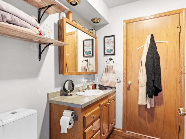 bathroom featuring wood-type flooring, vanity, and toilet