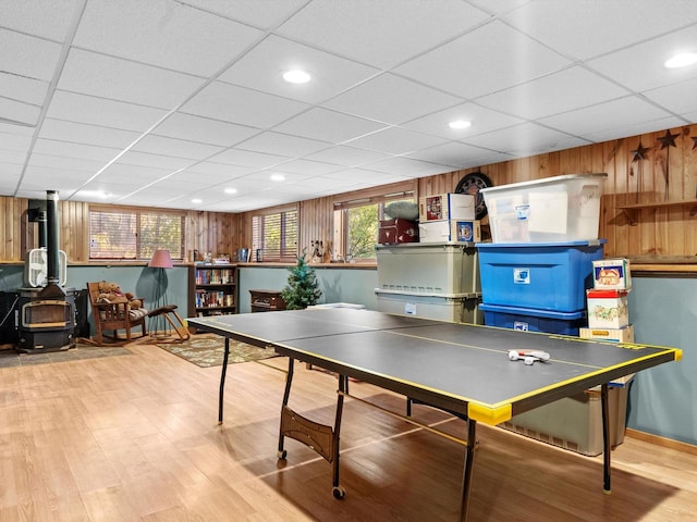 rec room with wood-type flooring, wooden walls, and a drop ceiling