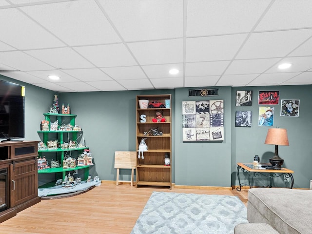 interior space featuring a paneled ceiling and hardwood / wood-style floors