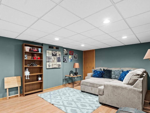 living room with hardwood / wood-style flooring and a paneled ceiling