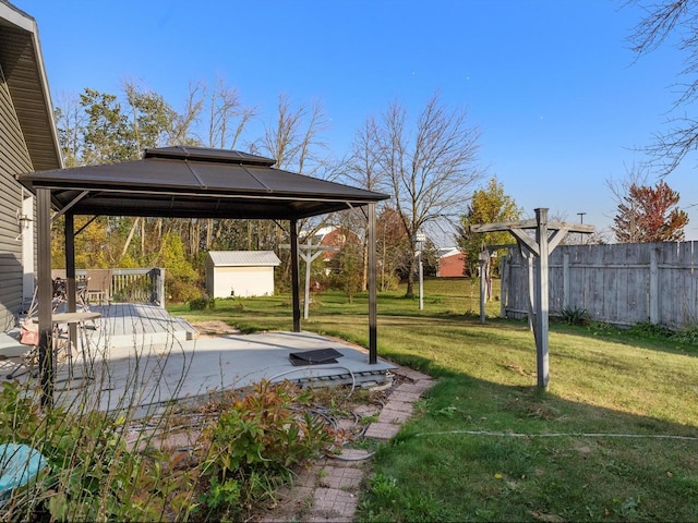 view of yard featuring a storage unit, a wooden deck, and a gazebo