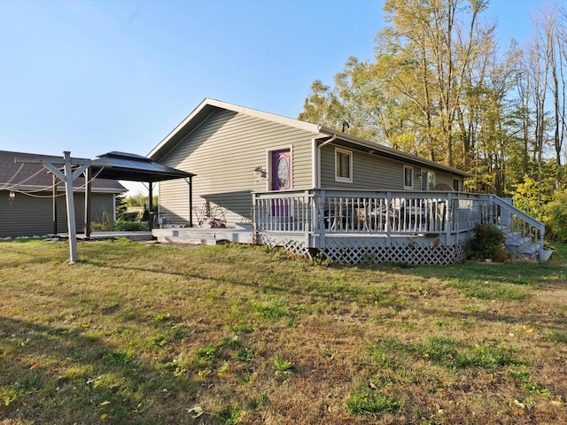 rear view of house with a wooden deck and a yard