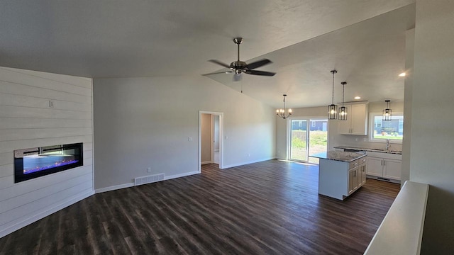 kitchen with white cabinets, lofted ceiling, dark hardwood / wood-style floors, and decorative light fixtures