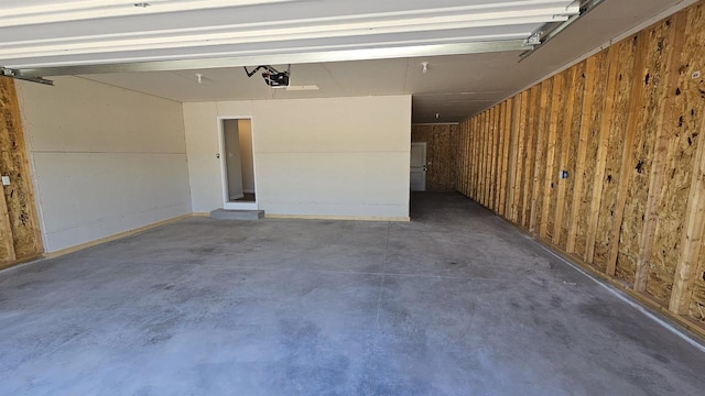 garage with a garage door opener and wooden walls