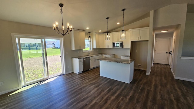 kitchen featuring appliances with stainless steel finishes, hanging light fixtures, white cabinetry, dark hardwood / wood-style flooring, and lofted ceiling