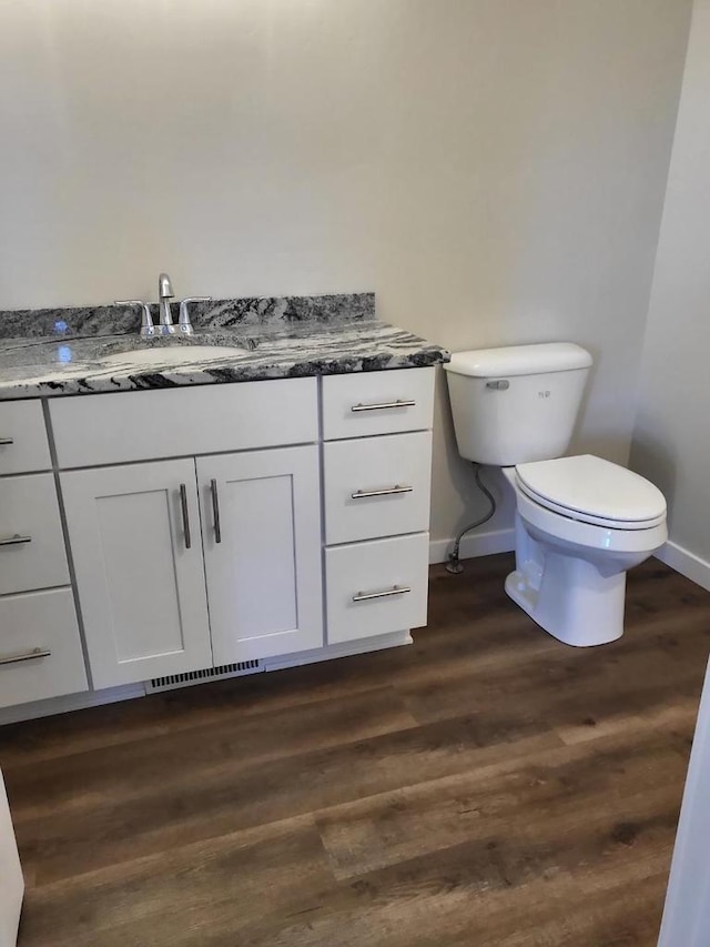 bathroom featuring wood-type flooring, vanity, and toilet