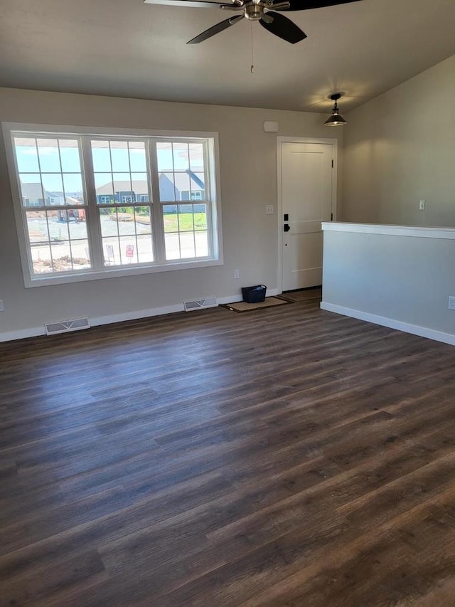 unfurnished living room with ceiling fan, plenty of natural light, and dark hardwood / wood-style flooring