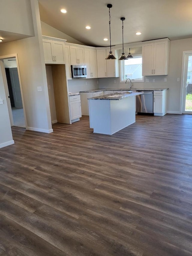 kitchen featuring lofted ceiling, white cabinetry, appliances with stainless steel finishes, and a kitchen island