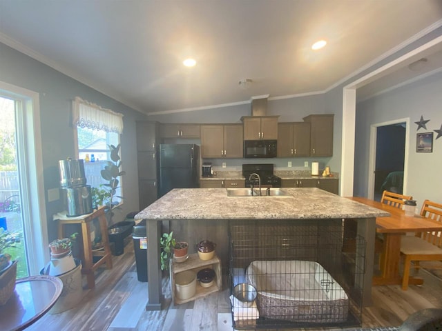 kitchen featuring vaulted ceiling, dark hardwood / wood-style flooring, crown molding, black appliances, and a center island with sink