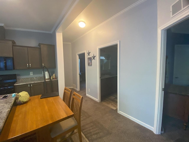 kitchen with dark carpet, black appliances, light stone counters, and ornamental molding