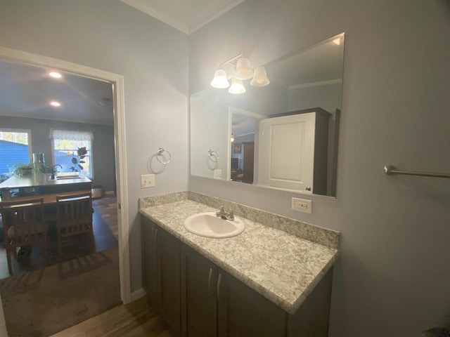 bathroom with ornamental molding, sink, and hardwood / wood-style flooring