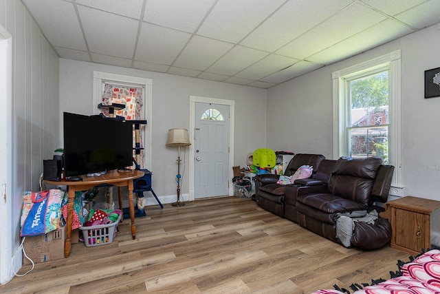 living room featuring a drop ceiling and light hardwood / wood-style floors