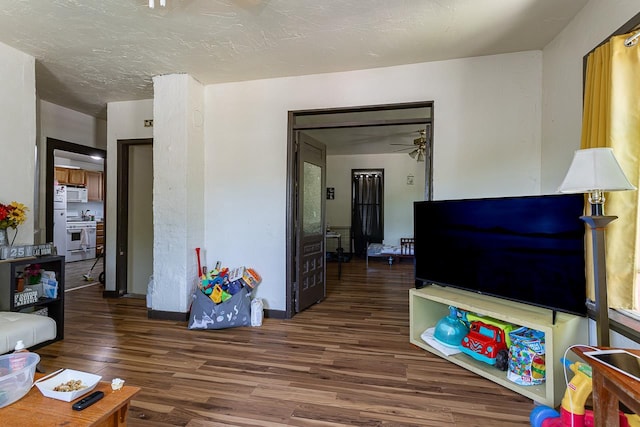 living room featuring a textured ceiling, dark hardwood / wood-style flooring, and ceiling fan