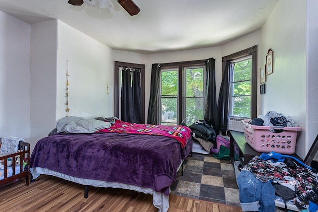 bedroom featuring ceiling fan, cooling unit, and dark wood-type flooring