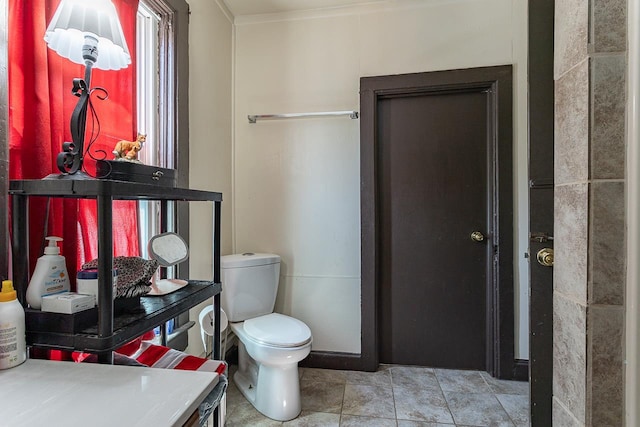 bathroom with ornamental molding and toilet