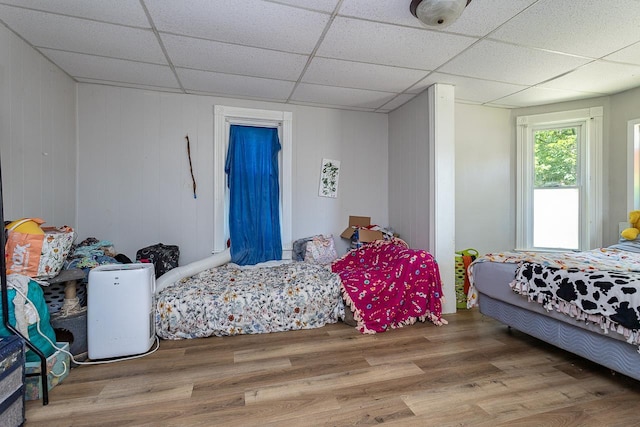 bedroom featuring a drop ceiling and hardwood / wood-style floors