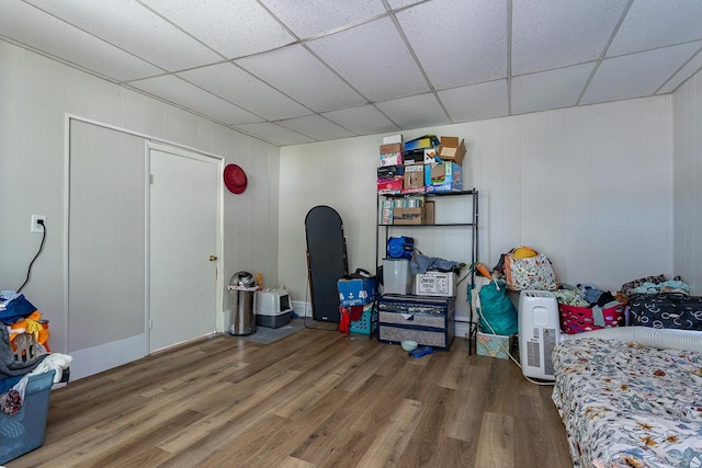 game room with hardwood / wood-style flooring, a drop ceiling, and wood walls