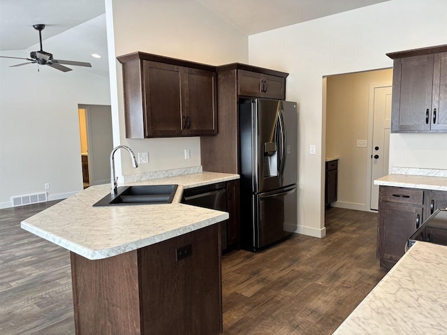 kitchen with sink, dark wood-type flooring, stainless steel fridge, and vaulted ceiling