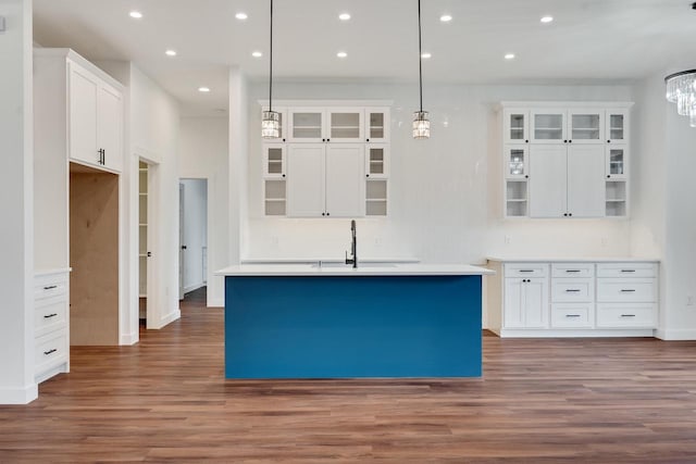 kitchen featuring sink, a center island with sink, decorative light fixtures, white cabinetry, and dark hardwood / wood-style flooring