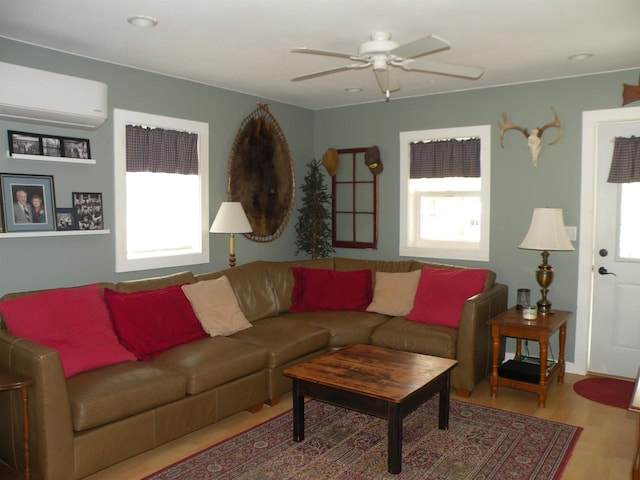 living room featuring light hardwood / wood-style floors, ceiling fan, and a wall mounted AC