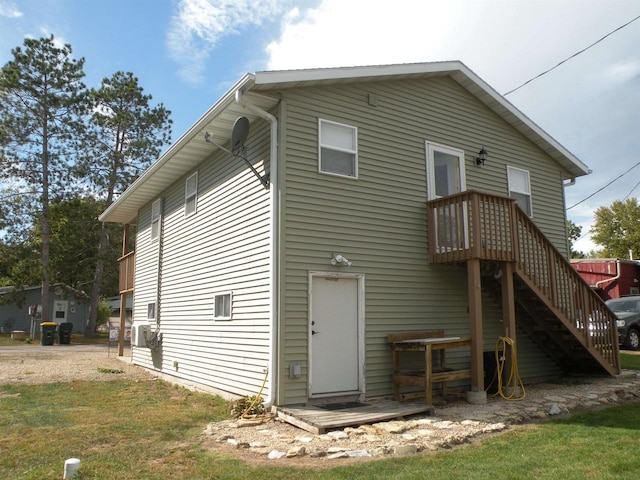 back of property with a wooden deck and a yard