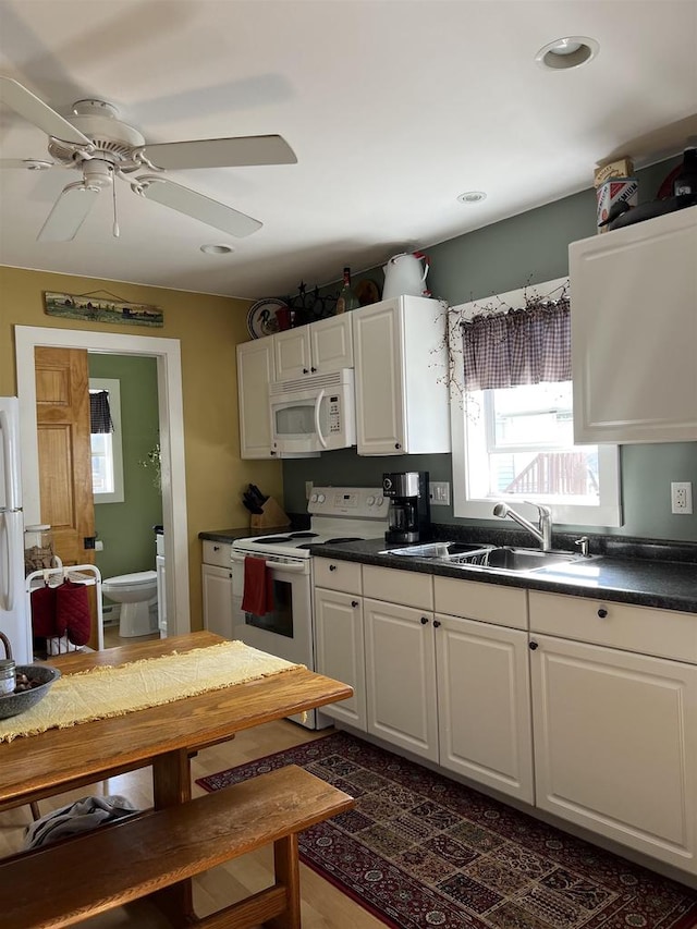 kitchen featuring dark hardwood / wood-style flooring, sink, white appliances, and white cabinetry