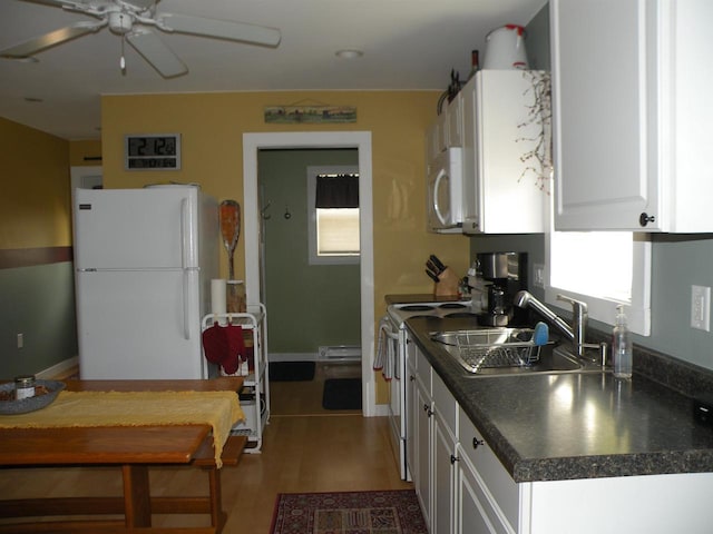 kitchen featuring white cabinets, sink, hardwood / wood-style floors, and white appliances