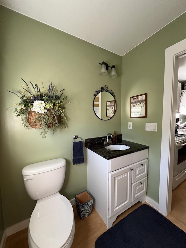 bathroom featuring hardwood / wood-style floors, vanity, and toilet