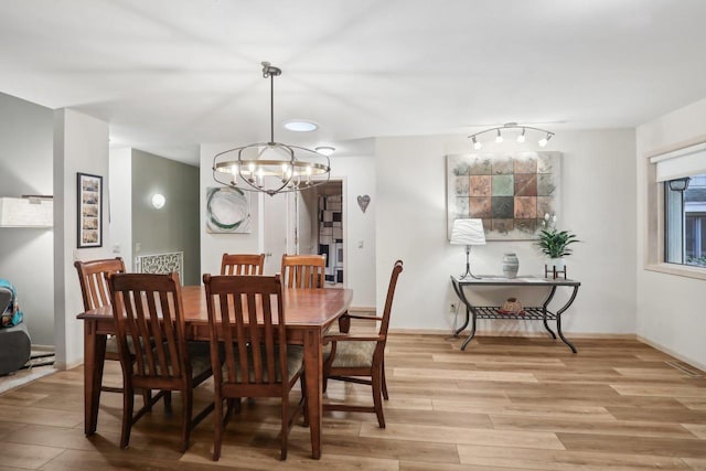 dining area with a notable chandelier and light wood-type flooring