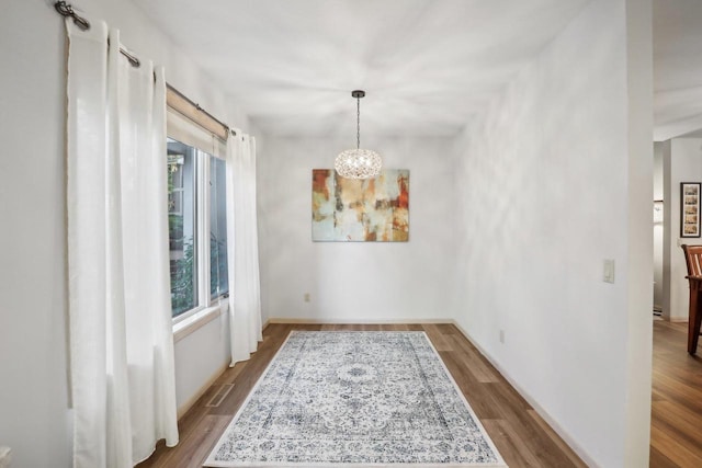 dining area featuring hardwood / wood-style floors and a chandelier