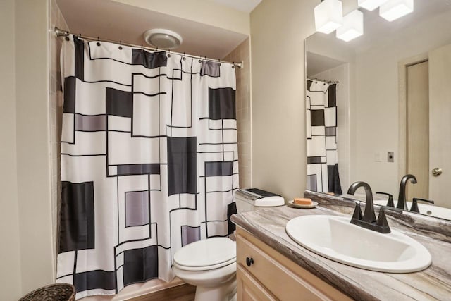 bathroom featuring vanity, hardwood / wood-style flooring, toilet, and walk in shower