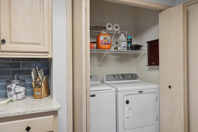 washroom featuring cabinets and washer and clothes dryer