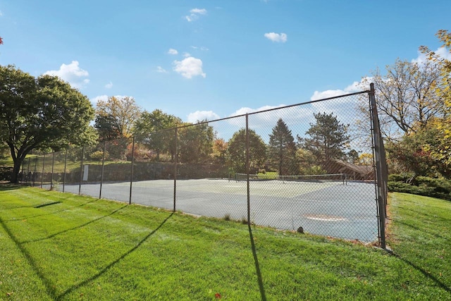 view of sport court with a lawn