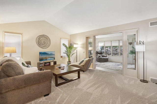 living room with vaulted ceiling and light colored carpet