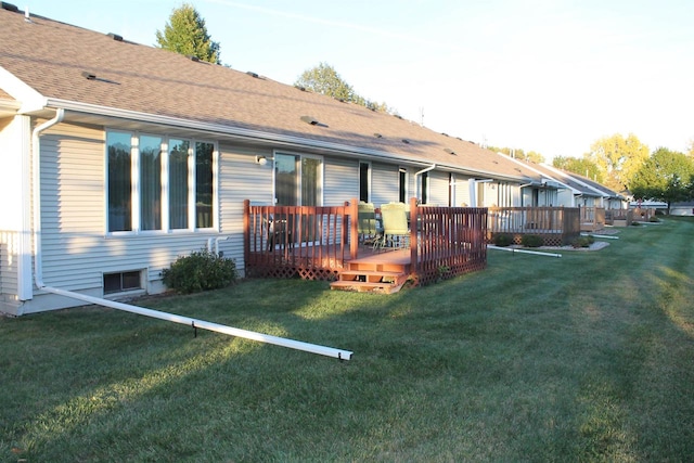 back of property featuring a lawn and a wooden deck