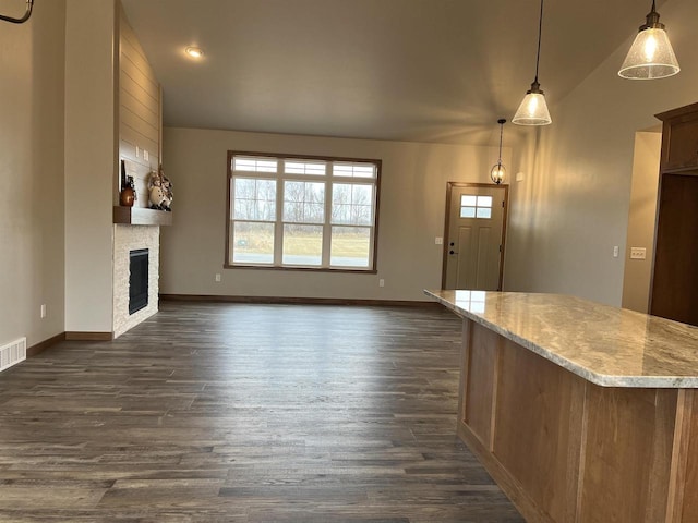 unfurnished living room with a fireplace, dark wood-type flooring, and lofted ceiling