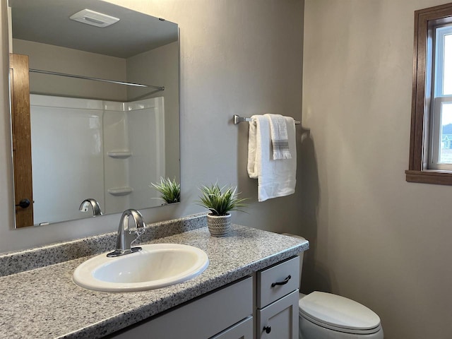 bathroom with a shower, toilet, and vanity