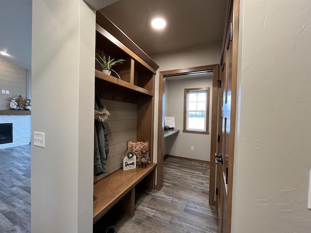 mudroom with a fireplace and dark hardwood / wood-style floors