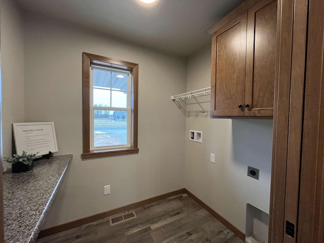 laundry area with hookup for an electric dryer, cabinets, washer hookup, and dark wood-type flooring