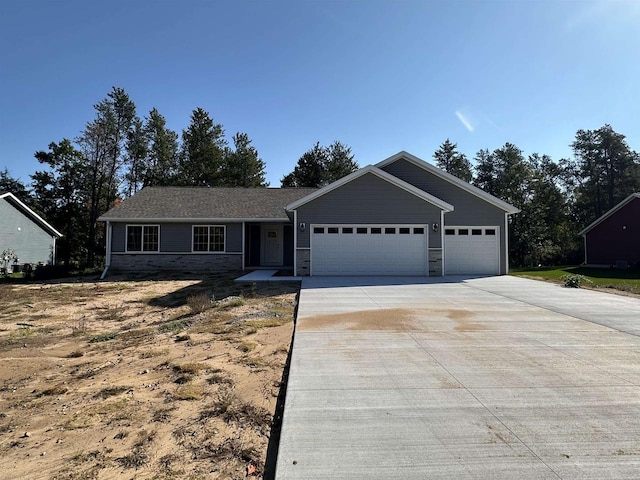 single story home with a garage, stone siding, and driveway